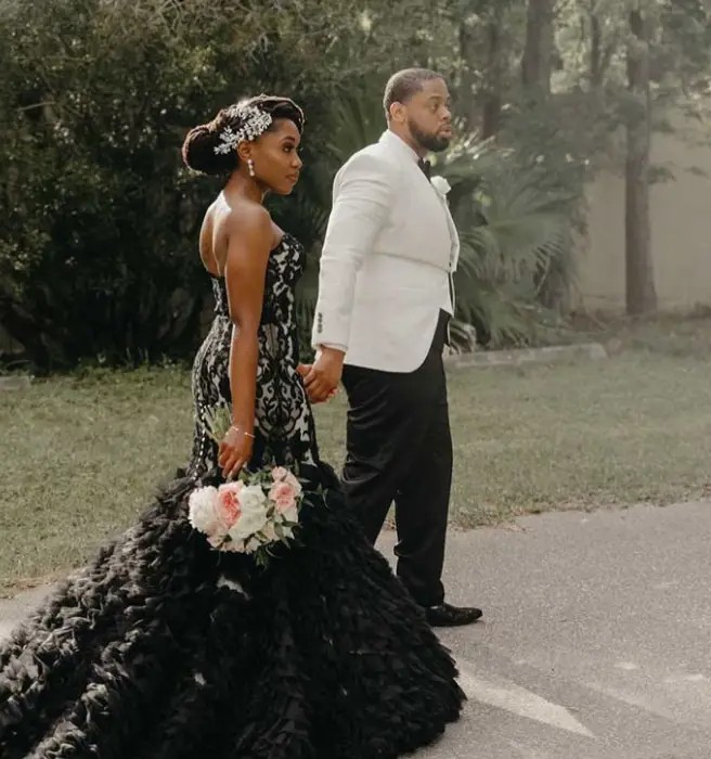 Сouple wearing a black gown and a white suit